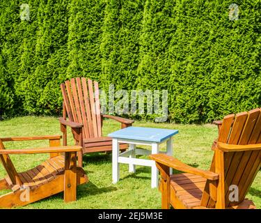 Kleiner Couchtisch und Holzstühle auf einem kleinen Netter grüner Hinterhof Stockfoto