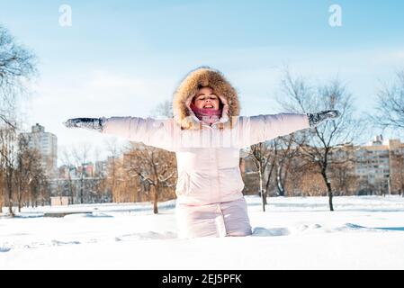 Mädchen tragen Winterhut, Schal mit Schneeflocken bedeckt. Aktiver Lebensstil. Stockfoto