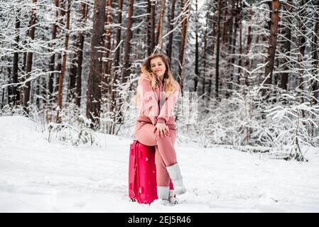 Mädchen wählt im Wald von einem kaputten Auto.Winterwald, Frost und Schnee Stockfoto