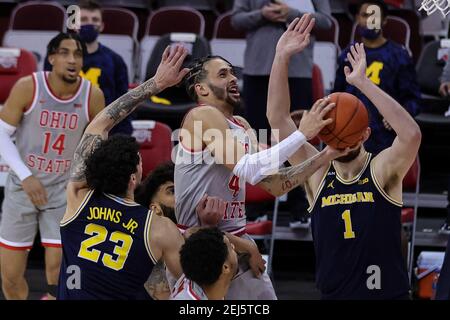 Columbus, Ohio, USA. Februar 2021, 21st. Ohio State Buckeyes Wache Duane Washington Jr. (4) fährt für einen Zwischenstopp zwischen Michigan Wolverines Stürmer Brandon Johns Jr. (23) und Wolverines Center Hunter Dickinson (1) im Spiel zwischen den Michigan Wolverines und den Ohio State Buckeyes in der Value City Arena, Columbus, Ohio. Quelle: Scott Stuart/ZUMA Wire/Alamy Live News Stockfoto