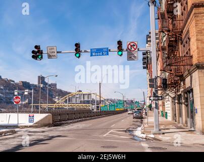 Geparkte Autos und Verkehr entlang Fort Pitt Boulevard mit der Fort Pitt Brücke im Hintergrund, Pittsburgh, Pennsylvania, USA Stockfoto