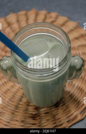 Vertikales Bild schließen Iced Matcha Tea auf grauem Steinhintergrund. Japanischer Grüner Tee Konzept. Zubereitung Von Matcha-Tee 2021. Stockfoto