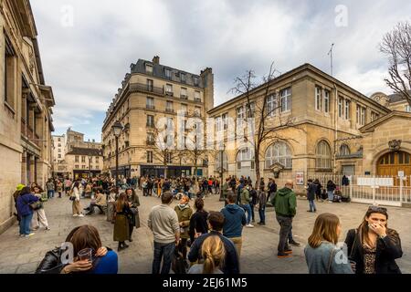 Paris, Frankreich - 21. Februar 2021: Menschen entspannen auf grünen Rasen des berühmten Place des Vosges - älteste geplante Platz in Paris, während covid-19 pandemi Stockfoto