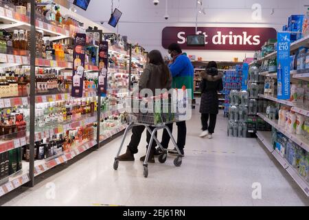 Einkäufer, die die Getränke in Alkohol oder Softgaisle auscheckten Stockfoto