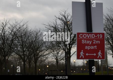 Schild: COVID-19 Aufenthalt 2m auseinander in der Impfstelle am Saxon Court, Milton Keynes. Stockfoto