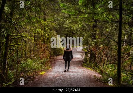 Mädchen zu Fuß im kanadischen Regenwald Stockfoto