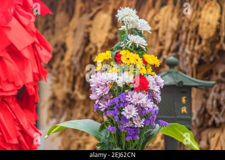 tokio, japan - april 12 2020: Nahaufnahme eines Blumenstraußes, der als Opfergabe in einem Tempel gezeigt wird und mit Chrysanthemen, Nelken, marigo gefüllt ist Stockfoto