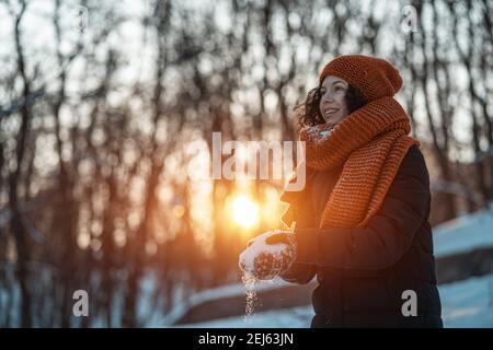 Schöne glückliche Frau mit Schnee spielen und Spaß im Freien haben Im Winterpark Stockfoto