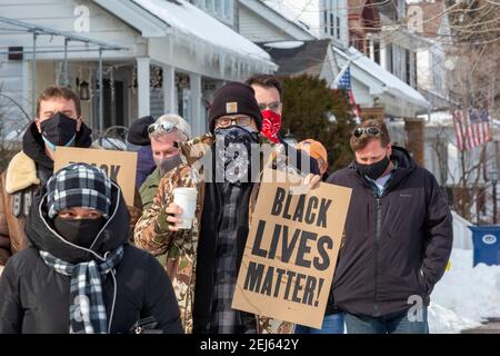 Große Pointe Park, Michigan, USA. Februar 2021, 21st. Mehrere hundert Menschen marschierten am Haus von je Donna Dinges vorbei, um Hass und Rassismus in ihrer historisch weißen Gemeinschaft zu protestieren. Am 15. Februar entdeckte die Afroamerikanerin Dinges, dass ihre Nachbarin eine Ku-Klux-Klan-Fahne im Fenster vor ihrem Haus aufgehängt hatte. Kredit: Jim West/Alamy Live Nachrichten Stockfoto