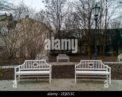 Lodz, Polen - Februar 22 2020 einige weiße Bänke in einem kleinen Park Stockfoto