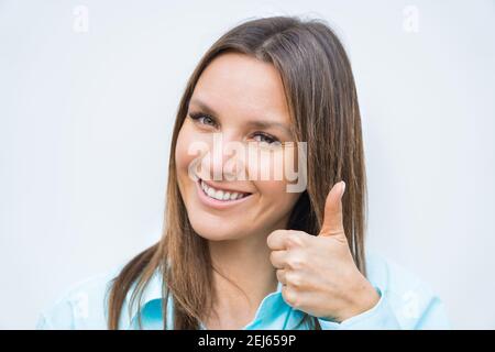 Nahaufnahme Porträt von jungen fröhlich glücklich lächelnd Geschäftsfrau zeigt Daumen nach oben. Positives Konzept Stockfoto