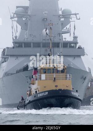 AJAXNETPHOTO. JANUAR 2009, 28TH. PORTSMOUTH, ENGLAND. - HEIMLICHE ANKUNFT - HMS DARING BEGLEITET VON SCHLEPPER SD BUSTLER, ERSTE DER ROYAL NAVY'S SECHS NEUE TYP 45 ZERSTÖRER, ANKUNFT IN PORTSMOUTH MARINESTÜTZPUNKT. FOTO:JONATHAN EASTLAND/AJAX REF:D92801 2254 1 Stockfoto