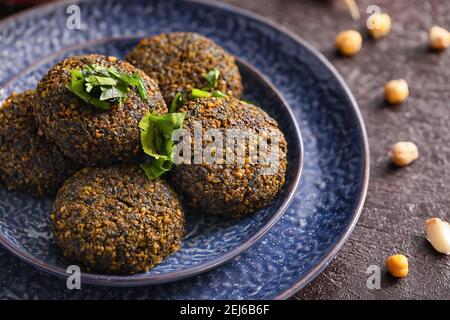 Teller mit leckeren Falafel Kugeln auf dunklem Hintergrund Stockfoto