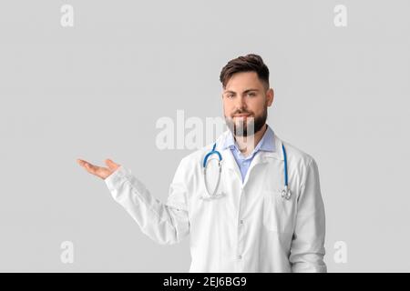 Doktor hält etwas auf hellem Hintergrund Stockfoto