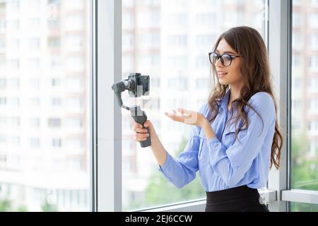 Junge Geschäftsfrau Aufnahme Video Blog auf Smartphone im Büro des Unternehmens Stockfoto