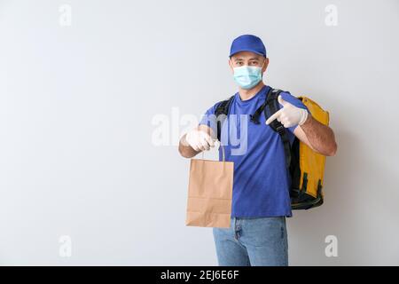 Kurier der Lebensmittelzustellung auf hellem Hintergrund Stockfoto
