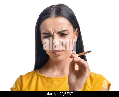 Angewiderte junge Frau mit Zigarette auf weißem Hintergrund. Konzept der Ablehnung von schlechten Gewohnheit Stockfoto