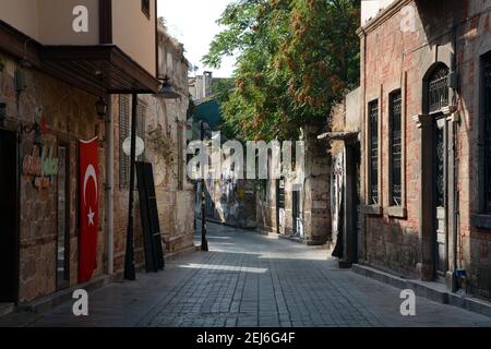 Ruhige und leere Seitenstraße in der Altstadt von Antalya am frühen Morgen. Die türkische Flagge hängt an einer Wand. September 2015 Stockfoto