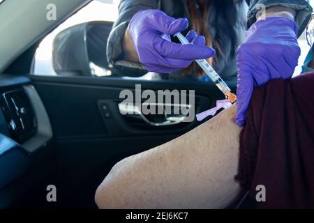 Eine 84-jährige Latina-Frau bekommt ihre zweite Moderna-Impfstoffinjektion, um die Ausbreitung des COVID-19-Virus zu stoppen; Dodger Stadium, L.A. CA USA. Stockfoto
