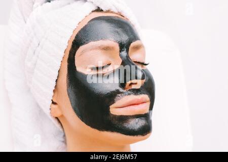 Frau mit schwarzer reinigender Holzkohle Gesichtsmaske im Spa. Kosmetologie und Hautpflege. Schönheitsbehandlungen. Spa-Therapie. Stockfoto