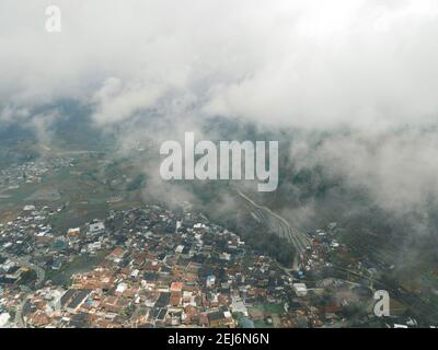 Luftaufnahme des Dorfes Dieng bei Wonosobo mit Berg ringsum IT Stockfoto