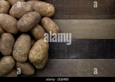 Foto von einem Haufen von Kartoffeln russet auf einem rustikalen Holztisch Stockfoto