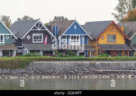 Bunte Holzhäuser am Ufer des Flusses in British Columbia, Kanada. Straßenansicht, Reisefoto, selektiver Fokus Stockfoto