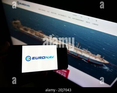 Person mit Mobiltelefon mit Firmenlogo der belgischen Reederei Euronav NV auf dem Bildschirm vor der Webseite. Fokus auf Handy-Display. Stockfoto