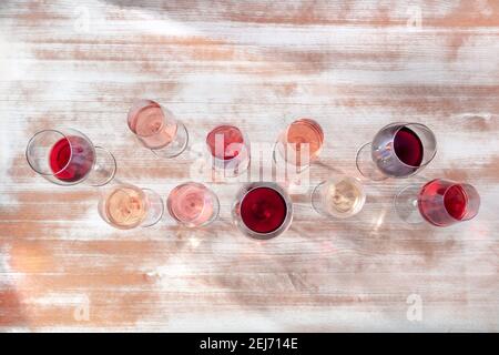 Weinfarben. Viele Gläser Weiß-, Rose- und Rotwein, oben flach lag Schuss Stockfoto