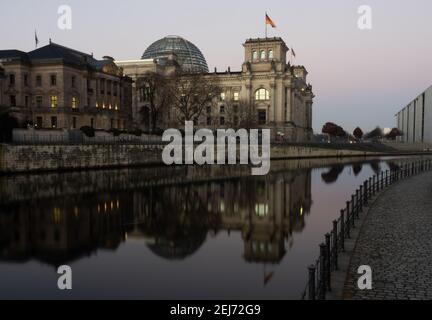 Berlin, Deutschland. Februar 2021, 22nd. Der Reichstag spiegelt sich am frühen Morgen in der Spree wider. Quelle: Paul Zinken/dpa-Zentralbild/dpa/Alamy Live News Stockfoto