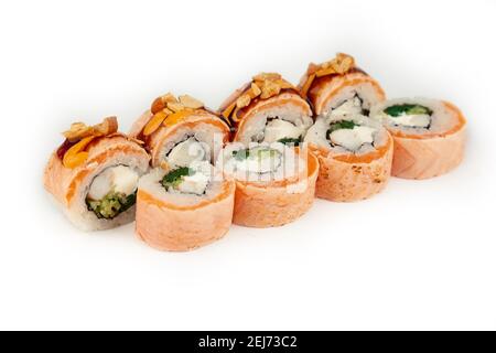 Sushi Roll mit Lachs Tataki und blanchiertem Spinat auf weißem Teller, Zutaten Lachs, Garnelen, blanchierter Spinat, Frischkäse, Gurke, würzige Sauce, Teriyaki Sauce, Cashews, Reis, nori Stockfoto