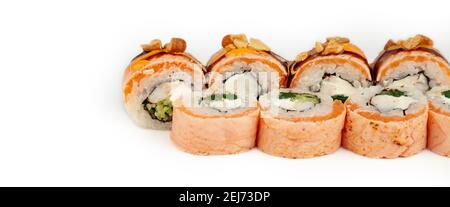 Sushi Roll mit Lachs Tataki und blanchiertem Spinat auf weißem Teller, Zutaten Lachs, Garnelen, blanchierter Spinat, Frischkäse, Gurke, würzige Sauce, Teriyaki Sauce, Cashews, Reis, nori Stockfoto