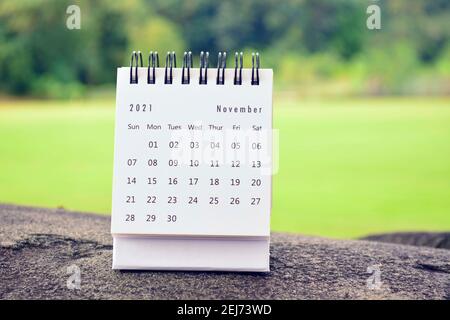 November 2021 weißer Kalender mit grün verschwommenem Hintergrund Stockfoto