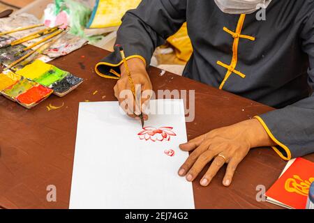 Nahaufnahme des älteren Mannes, der Lotusblume zeichnet Kalligrafie-Pinsel Stockfoto