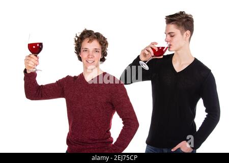 Feiertage und Wochenenden. Junges attraktives Paar trinkt Rotwein. Weißer Hintergrund. Stockfoto