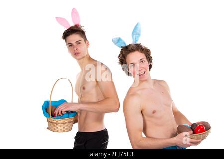 Feiertage und Wochenenden. Junges attraktives Paar zu Ostern in Hasen-Kostümen. Weißer Hintergrund. Stockfoto