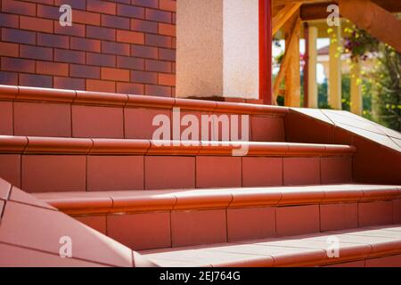 Stufen aus braunen Klinkerfliesen. Cottage Veranda Stockfoto