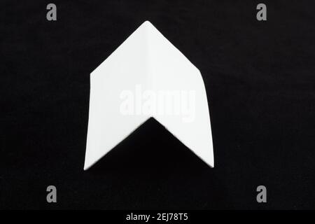 Weißes Blatt Papier auf schwarzem Hintergrund Stockfoto