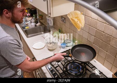 Ein Teenager wirft einen Pfannkuchen am Pfannkuchen-Tag, Faschingsdienstag Stockfoto