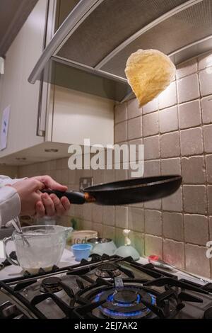 Ein Teenager wirft einen Pfannkuchen am Pfannkuchen-Tag, Faschingsdienstag Stockfoto