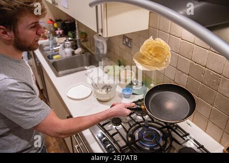 Ein Teenager wirft einen Pfannkuchen am Pfannkuchen-Tag, Faschingsdienstag Stockfoto