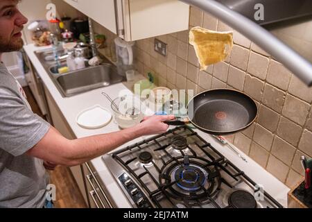 Ein Teenager wirft einen Pfannkuchen am Pfannkuchen-Tag, Faschingsdienstag Stockfoto