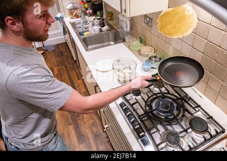 Ein Teenager wirft einen Pfannkuchen am Pfannkuchen-Tag, Faschingsdienstag Stockfoto