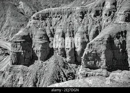 Graustufen Aufnahme von wunderschönen felsigen Bergen entlang der Straße in Borrego Springs, Kalifornien Stockfoto