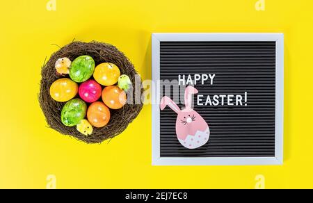 Ostereier im Nest und Holzhäschen auf Brief Platine Stockfoto