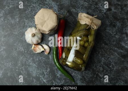 Glas mit eingelegten Gurken und Zutaten auf schwarzem Smokey Stockfoto