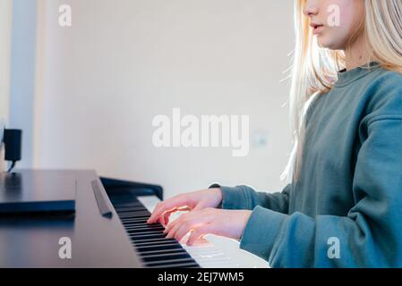 Ein Mädchen im Teenageralter spielt zu Hause E-Piano Stockfoto