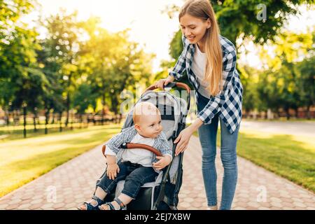 Mutter geht mit einer Babykutsche und einem Baby in der Stadt, das Konzept der Liebe und Familie Stockfoto