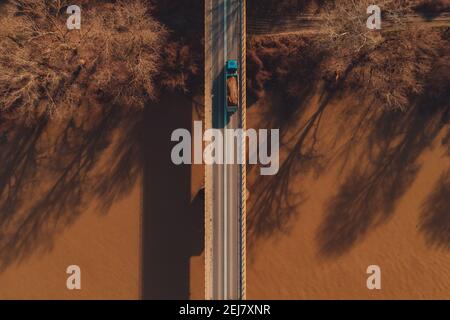 Luftaufnahme von LKW, der Schmutz über die Betonbrücke transportiert, Draufsicht Stockfoto