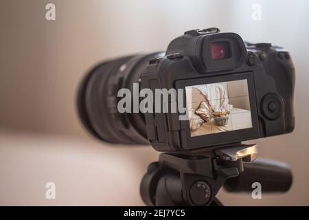 Nahaufnahme einer professionellen Digitalkamera auf einem Stativ auf unscharfem Hintergrund. Das Konzept der Technik für die Arbeit mit Fotos und Videos. Stockfoto